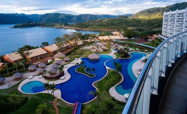 Vista aérea das piscinas do Tayayá Aqua Resort à beira do lago, com a varanda do hotel em primeiro plano